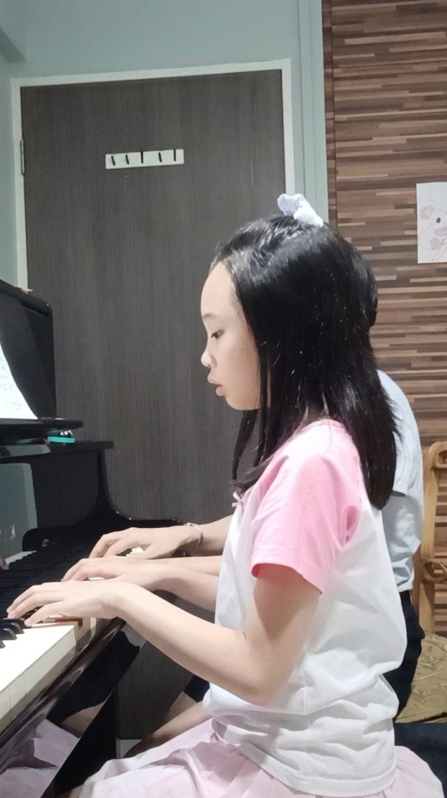 Piano teacher providing one-on-one instruction to a student
