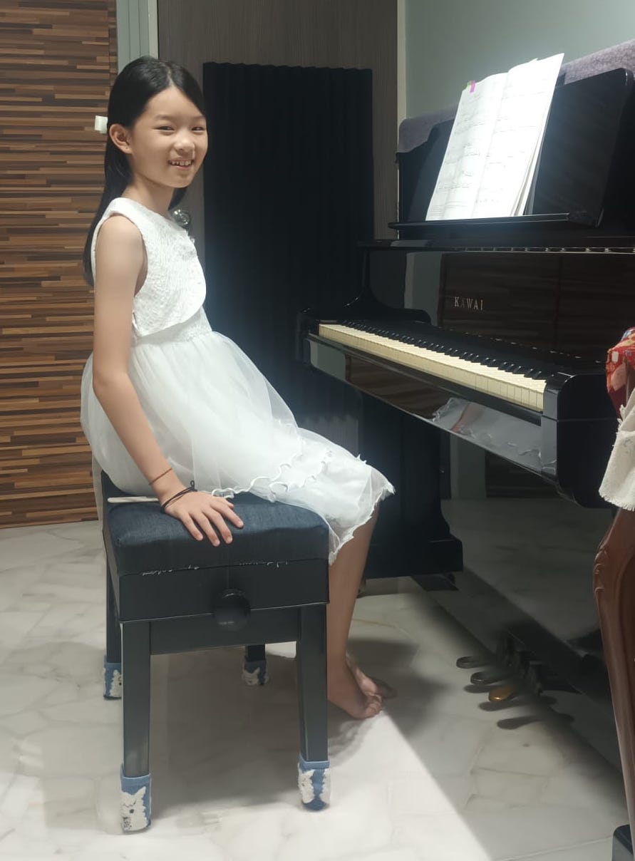 An introductory piano trial session showing a student happily playing their first few notes.